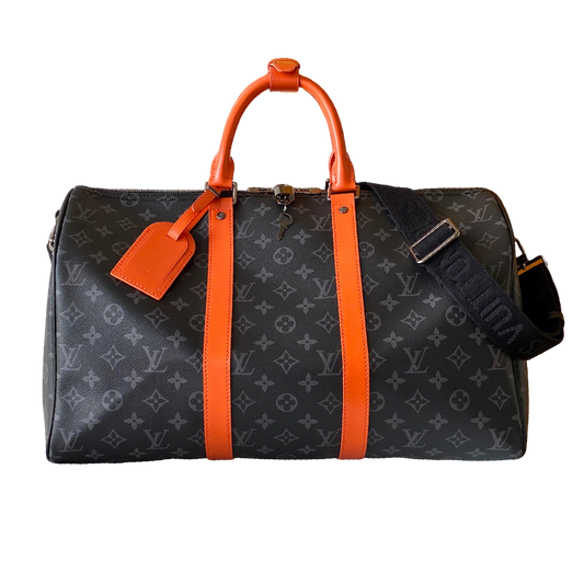 Louis Vuitton Monogram Canvas Travel Bag With Vibrant Orange Accents For Stylish Journeys