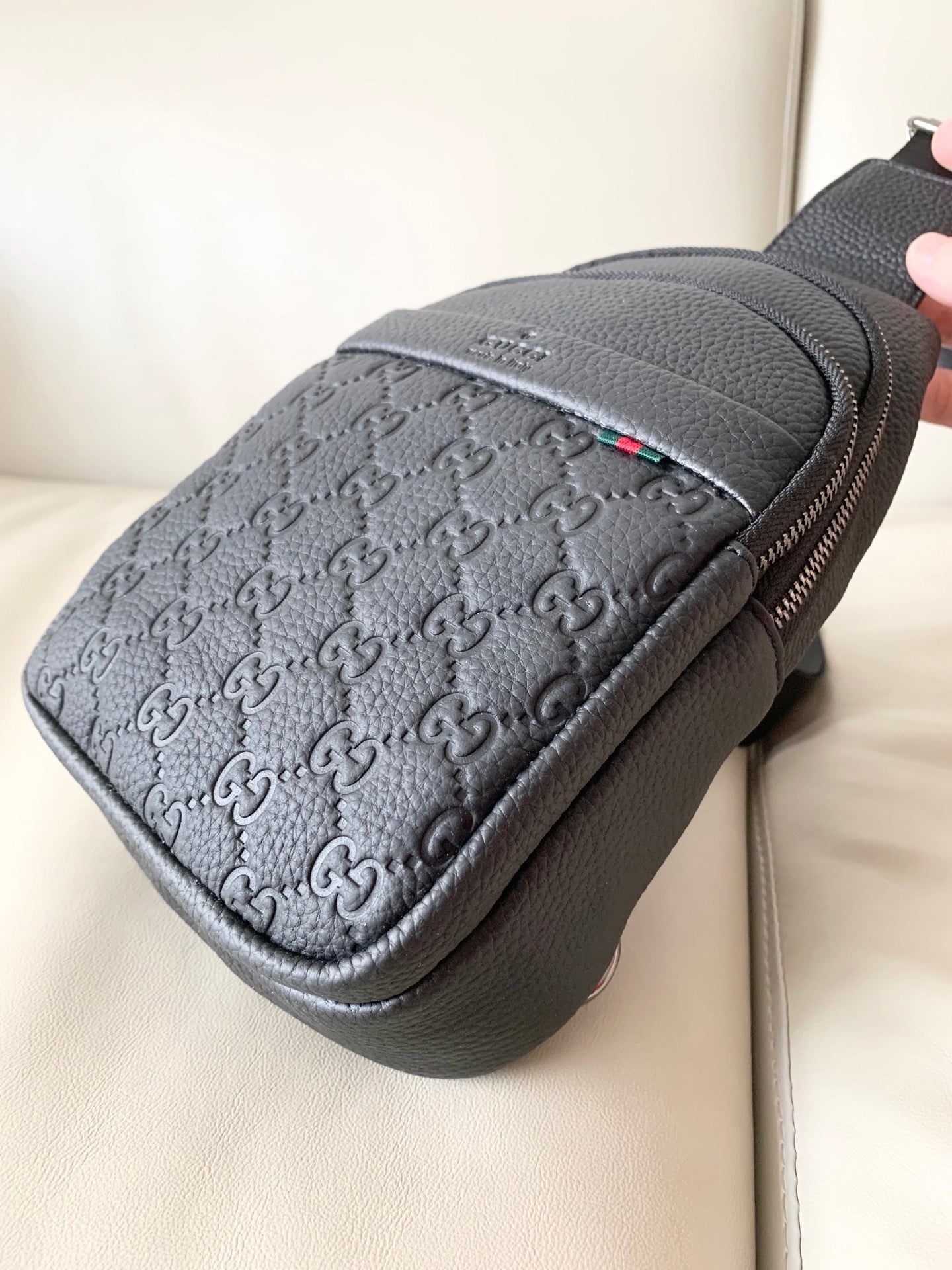 Stylish Black Gucci Sling Bag With Embossed GG Pattern And Brand Detailing For Modern Fashion 3218